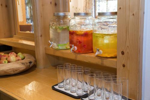 a row of wine glasses on a shelf with fruit at Familienhotel Mateera Gargellen / Montafon in Gargellen