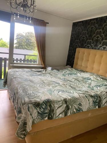 a bed in a bedroom with a large window at Swden Sunne in Sunne