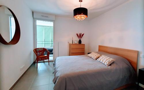 une chambre avec un lit, un miroir et une chaise dans l'établissement LE REVEST Terrasse Vue Mer Centre Climatisation Parking, à Sète