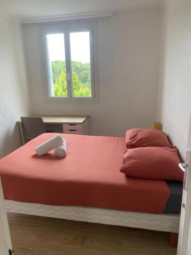 Un dormitorio con una cama con sábanas rojas y una ventana en Spacieux - lumineux - 3 couchages - Quimper centre, en Quimper