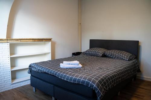 1 dormitorio con 1 cama con 2 toallas en Kess Maison, Gehele villa met dakterras Enschede, en Enschede