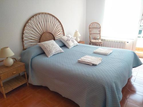 1 dormitorio con 1 cama azul y 2 toallas en Solete en Suances