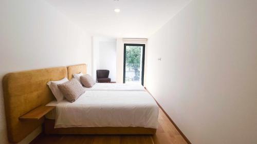 a bedroom with a bed and a window at Apolo71 Alojamentos in Bragança