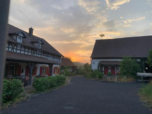 un coucher de soleil dans un village avec des maisons et une rue dans l'établissement Bezauberndes Häuschen auf historischer Hofstelle, 