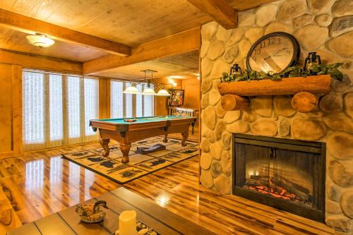 a living room with a pool table and a stone fireplace at Spacious Twin Mountain Vacation Rental on 5 Acres! in Twin Mountain