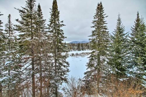 a snow covered forest with trees and a lake at Spacious Twin Mountain Vacation Rental on 5 Acres! in Twin Mountain