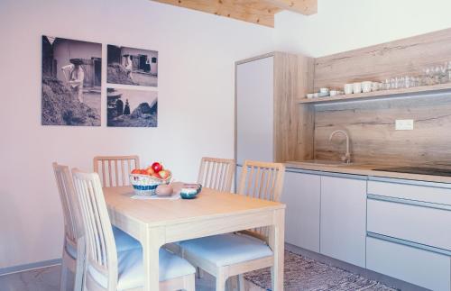 eine Küche mit einem Tisch, Stühlen und einem Waschbecken in der Unterkunft Chata ŠENKÁRKA Zuberec in Zuberec