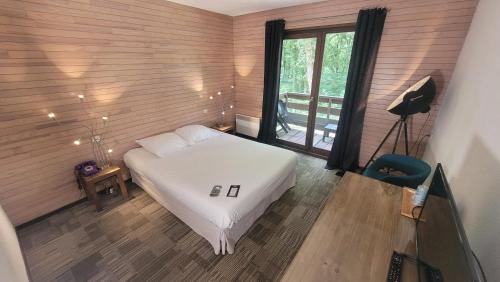 a bedroom with a white bed and a window at Enzo Hotels ST ELOY Metz Amneville By Kyriad Direct in Amnéville