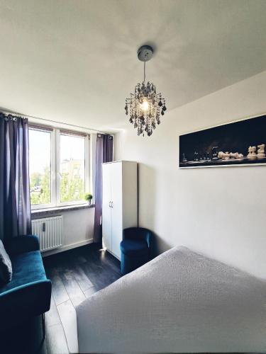 a bedroom with a bed and a chandelier at Apartament nad Pisą in Pisz