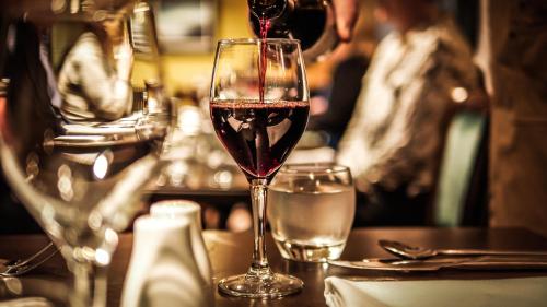 a glass of red wine sitting on a table at Denvir's of Downpatrick in Downpatrick