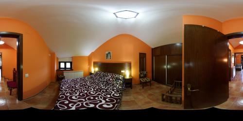a bedroom with a large bed in a room with orange walls at Casa rural Rosita in Santa Cruz de los Cuérragos
