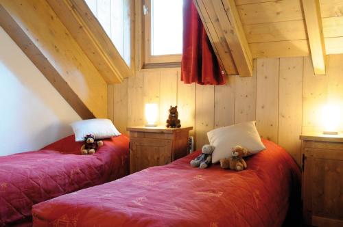 two beds with teddy bears sitting on them in a room at Lagrange Vacances Les Arolles in Saint-Gervais-les-Bains