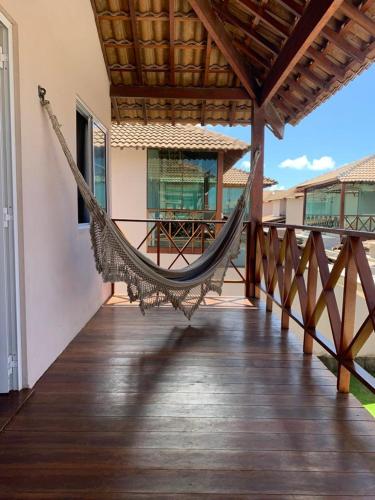 a hammock on the porch of a house at Condomínio Village 4 Carneiros casa 40 in Tamandaré