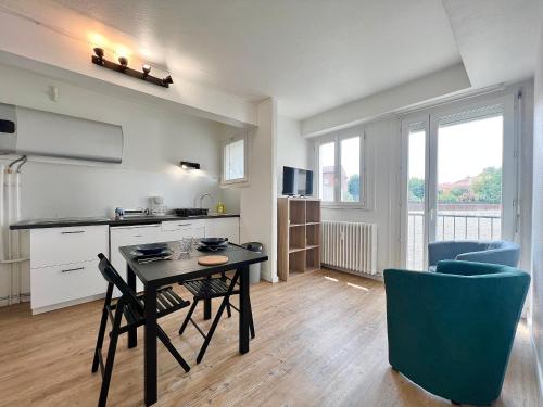 une cuisine et une salle à manger avec une table et des chaises dans l'établissement Le Saint Agne, à Toulouse
