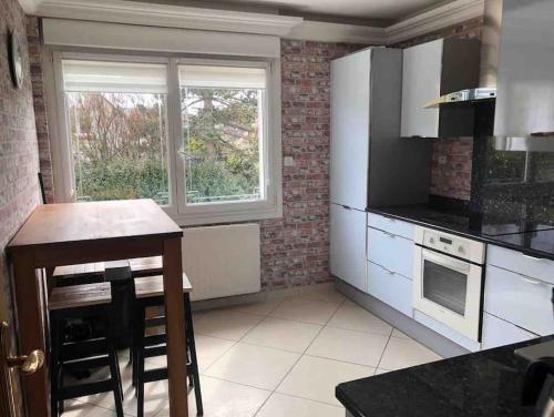 une cuisine avec des appareils électroménagers blancs et une fenêtre dans l'établissement Maison de ville proche de la mer, à Le Portel