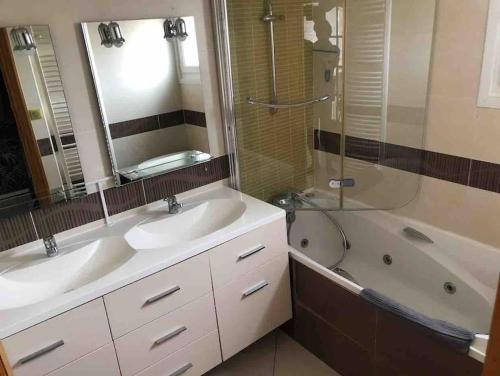 La salle de bains est pourvue de 2 lavabos, d'une douche et d'une baignoire. dans l'établissement Maison de ville proche de la mer, à Le Portel