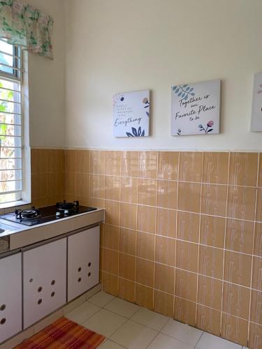a kitchen with brown tiles on the wall and a sink at Magnolia homestay 2 