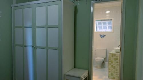 a bathroom with a toilet and a green wall at Casa com lareira e lazer, em Campos do Jordao SP in Campos do Jordão