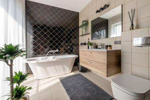 uma casa de banho com uma banheira, um WC e um lavatório. em Luxurious penthouse with parking em Riga
