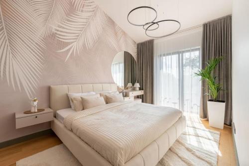 sypialnia z dużym łóżkiem i dużym oknem w obiekcie Luxurious penthouse with parking w Rydze