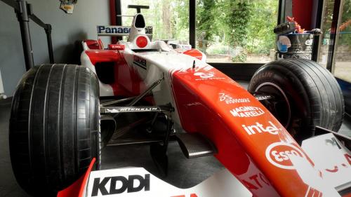 a red race car parked in a garage at Enzo Hôtels - ST Eloy Metz Amneville By Kyriad Direct in Amnéville
