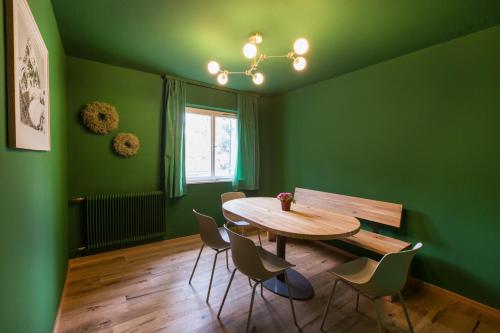 a green dining room with a wooden table and chairs at Familienhotel Mateera Gargellen / Montafon in Gargellen