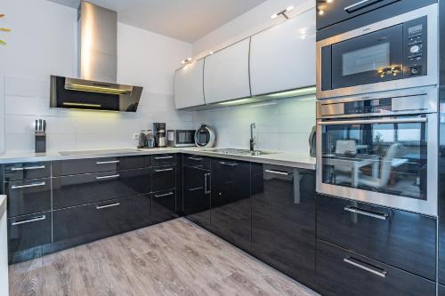 a kitchen with black cabinets and white appliances at Mona in Westerland (Sylt)