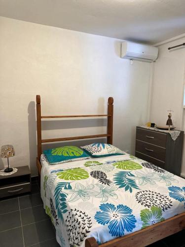 um quarto com uma cama com um edredão azul e branco em AZARIA em Le Gosier