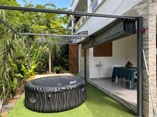 un patio extérieur avec un grand pneu sur l'herbe dans l'établissement AZARIA, au Gosier