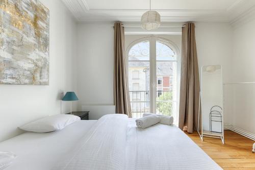 une chambre blanche avec deux lits et une fenêtre dans l'établissement La Terrasse à 15min de Disneyland Paris, à Lagny-sur-Marne