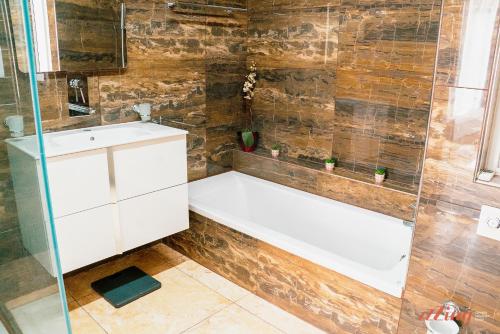 a bathroom with a white tub and a glass shower at A seaside holiday home with country views in Żebbuġ