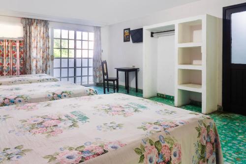1 dormitorio con 2 camas, mesa y ventana en OYO Hotel San Martin, en Veracruz