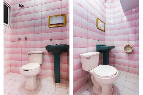 een roze betegelde badkamer met 2 toiletten en een wastafel bij OYO Hotel San Martin in Veracruz