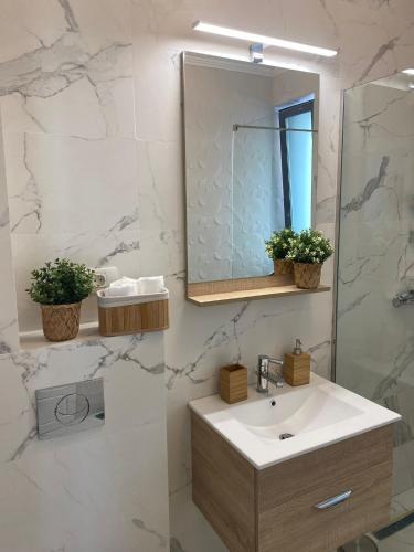 a bathroom with a sink and a mirror at Queen's Studio Deluxe Mamaia Nord in Mamaia Nord