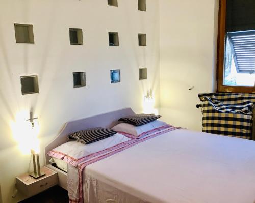 a bedroom with a large white bed with two pillows at Night Galleria Holiday Villa Liguria 