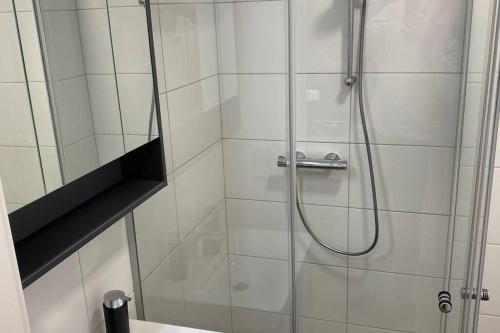 a shower with a glass door next to a sink at Serviced Appartements im Zentrum Rohrbach #Komplett ausgestattet in Rohrbach-Berg