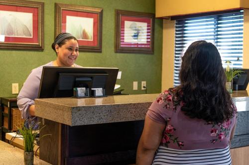 a woman standing at a cash register in a store at Wingate by Wyndham Sioux City in Sioux City