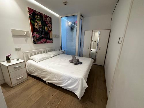Un dormitorio con una cama con un osito de peluche. en Ground floor flat in Maida Vale, en Londres