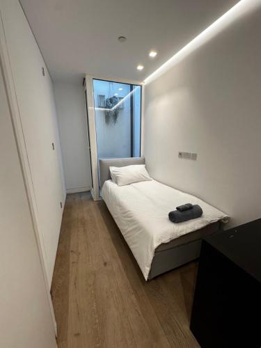 Habitación pequeña con cama y ventana en Ground floor flat in Maida Vale, en Londres