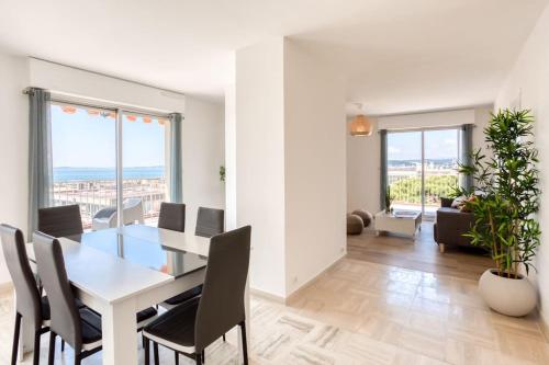 une salle à manger et un salon avec une table et des chaises dans l'établissement L43 Suite Maurice sea view 6Pax/Terrace,Parking,AC, à Saint-Laurent-du-Var