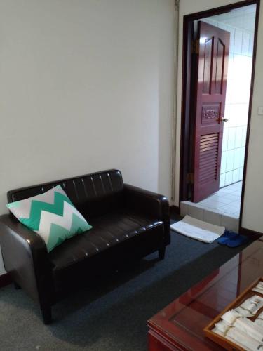 a black leather couch in a living room with a mirror at River Hotel in Chiayi City