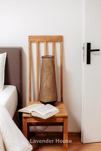 a lamp and a book on a chair next to a bed at Lavender House in Osieki
