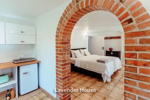 a bedroom with a bed and a brick wall at Lavender House in Osieki