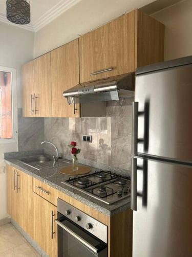 uma cozinha com um fogão e um frigorífico em Appartement jnane aourad em Marrakech