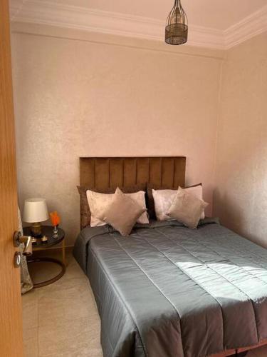 um quarto com uma cama com almofadas em Appartement jnane aourad em Marrakech