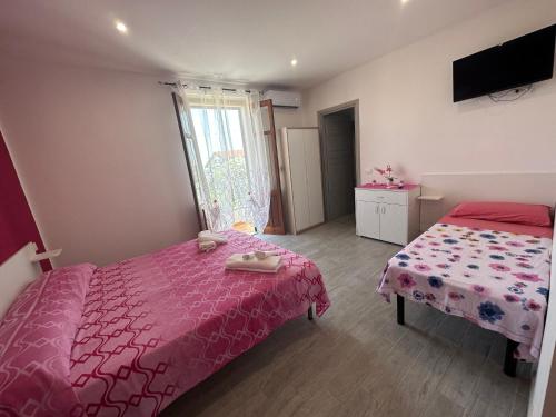 a bedroom with two beds and a pink bedspread at Appartamento Orchidea in Parghelia