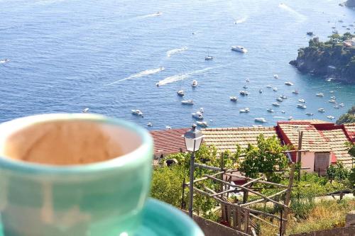 a cup of coffee with a view of a body of water at Amalfi Rooms Duoglio Beach -amazing seaview in Amalfi
