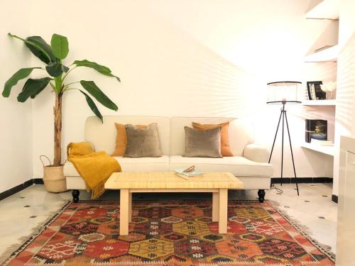 - un salon avec un canapé blanc et une table basse dans l'établissement Moderno Apartamento Cerca a Plaza España, à Séville