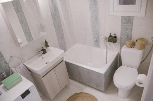 La salle de bains blanche est pourvue de toilettes et d'un lavabo. dans l'établissement Just A Stay apartement, à Chios