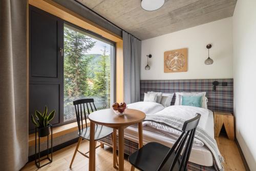 a bedroom with a bed and a table and chairs at XYZ eXtreme You Zen in Szczyrk